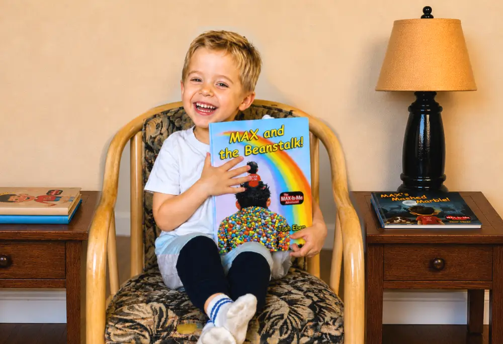 Smiling young reader holding MAX and the Beanstalk!